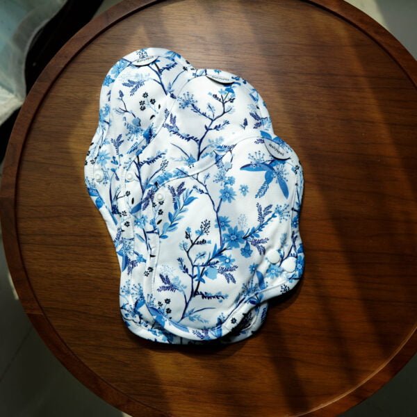 3 Sizes for light to heavy flow of Haliya Cup reusable menstrual cloth pad with microfleece surface fabric that is easy to wash, resists stain and durable. Waterproof PUL is used as back part with blue floral pattern.